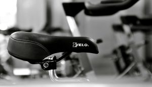 Detailed black and white shot of a gym bicycle saddle, highlighting fitness equipment aesthetics.